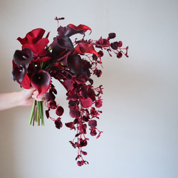 カラーリリィや胡蝶蘭を束ねたワインレッドのモダンブーケ