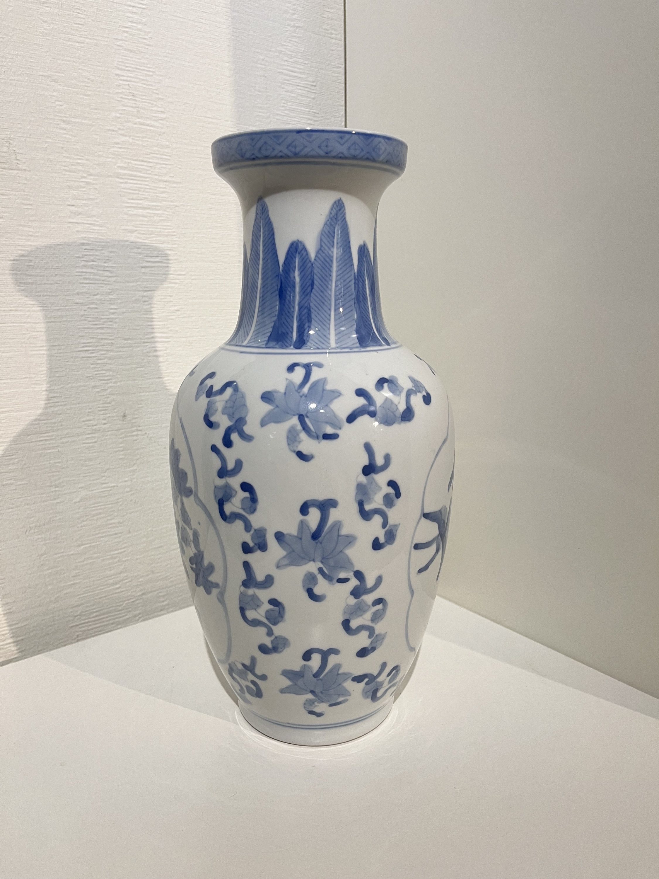 鳥と花のモチーフが特徴的な中国風磁器の花瓶。青と白。高さ 30 cm